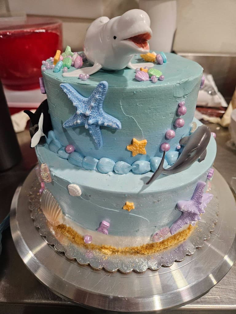 Ocean-themed custom event cake with a beluga whale topper
